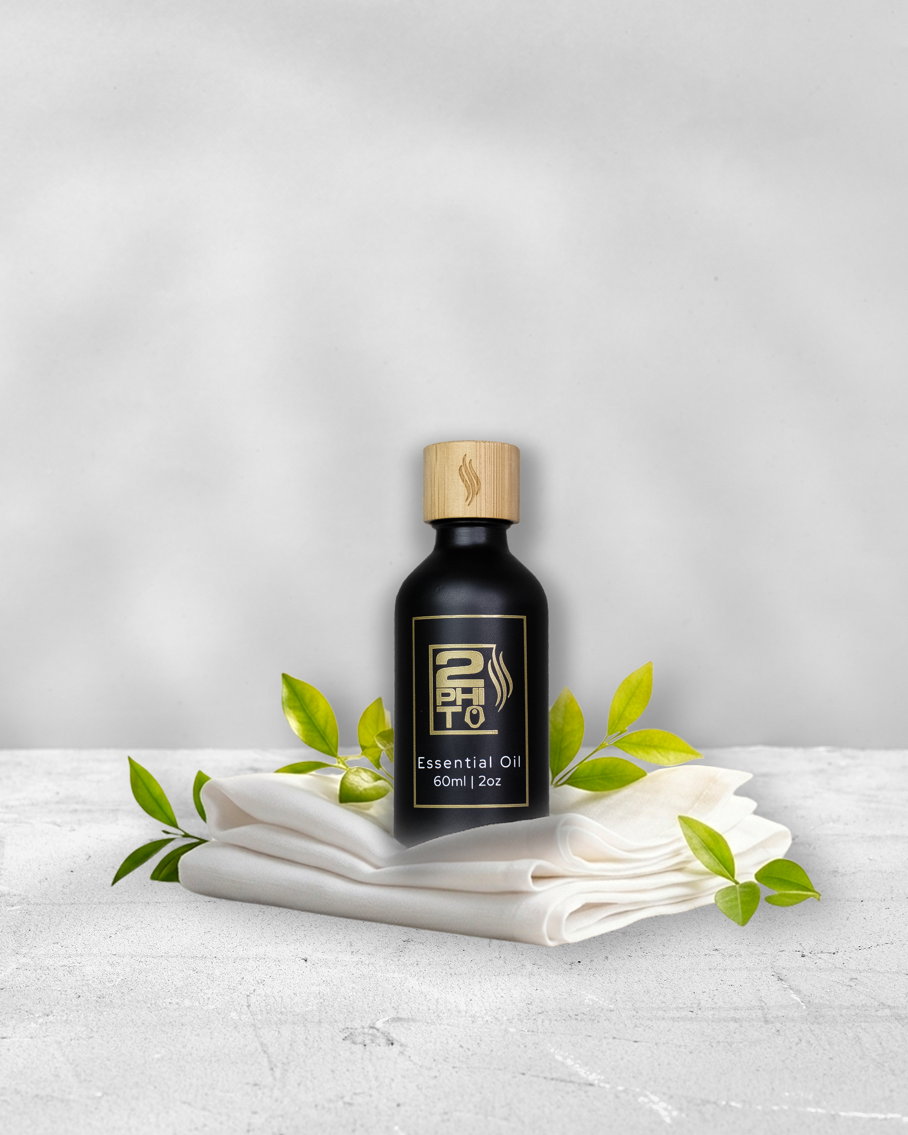 Botella de aceite esencial sobre telas, fragancia ropa secada al sol, 60ml, con hojas verdes decorativas.